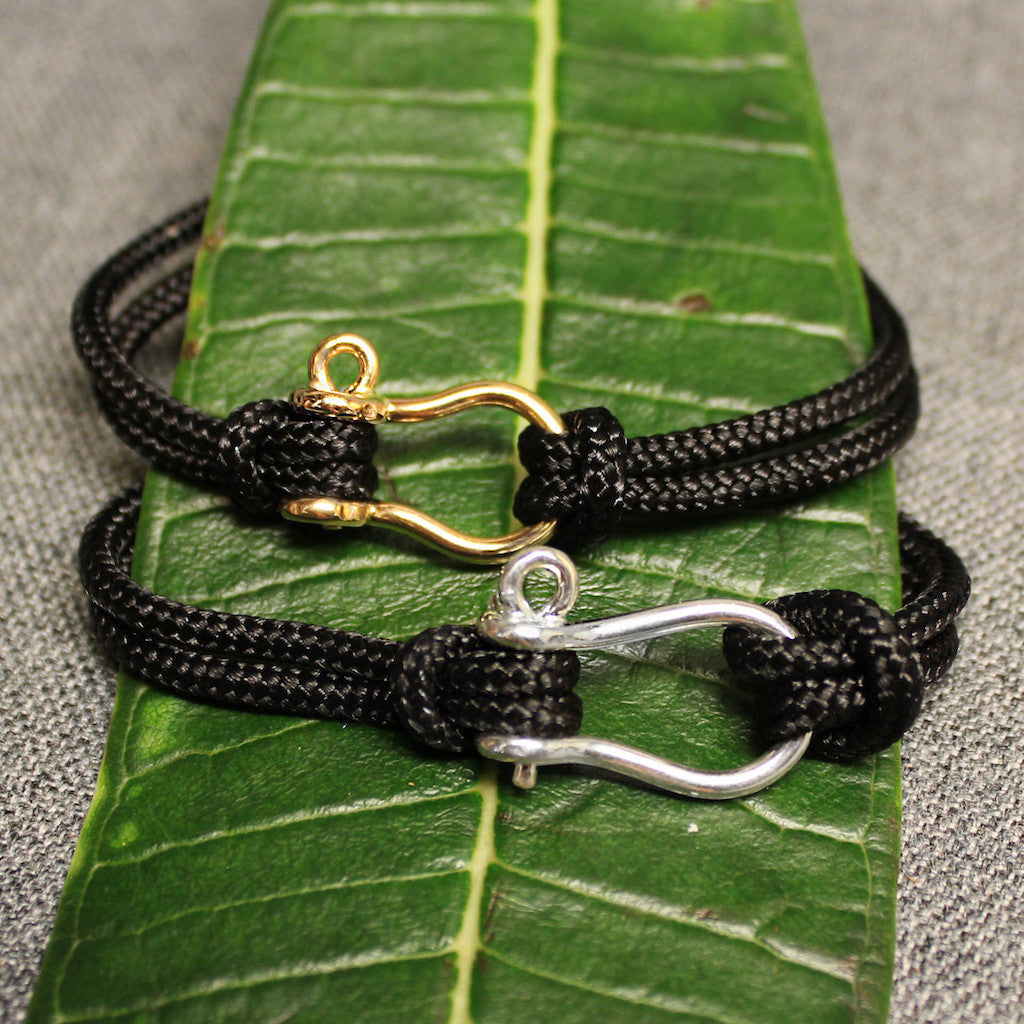 Sterling silver and 14k gold Sailor's Shackle adjustable black nylon cord bracelet.