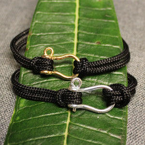 Sterling silver and 14k gold Sailor's Shackle adjustable black nylon cord bracelet.