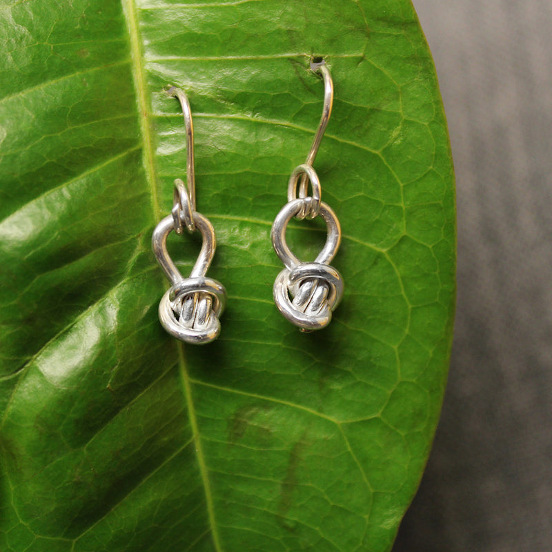Sterling silver charm earrings for child with small Crucian knot design.