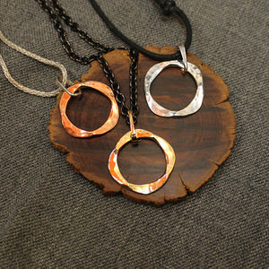 Handcrafted artisan pendants with circular design available in copper, sterling silver and 14k gold.