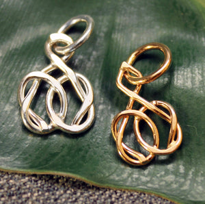 Sterling silver and 14k gold charms with friendship knot design.