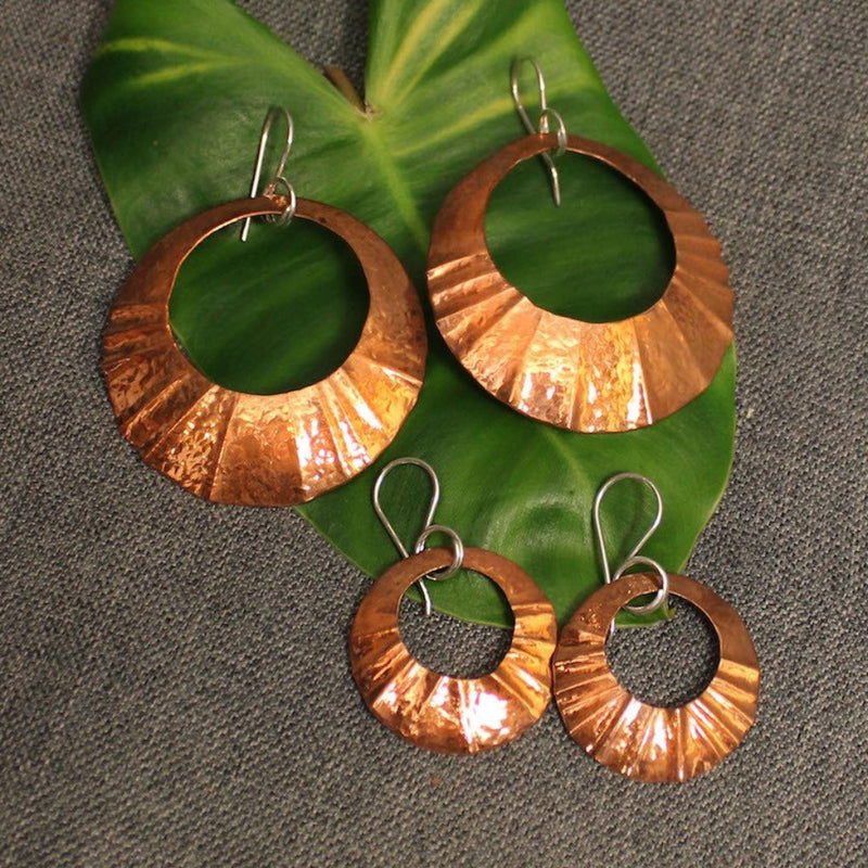 Small and large hammered circular copper earrings.
