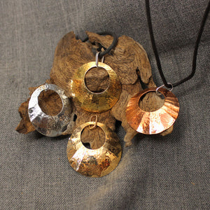 Brass, copper, sterling silver and 14 gold hammered circular pendants.