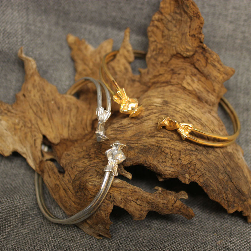 Sterling silver and 14k gold cuff bracelets with hand crafted Moko Jumbie design.