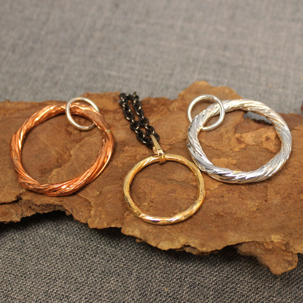 Handcrafted copper, sterling silver and 14k gold hoop pendants.