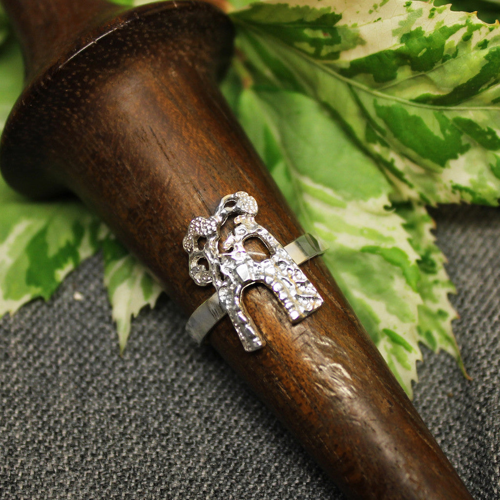 Thin sterling silver ring with handcrafted sugar mill design in center.
