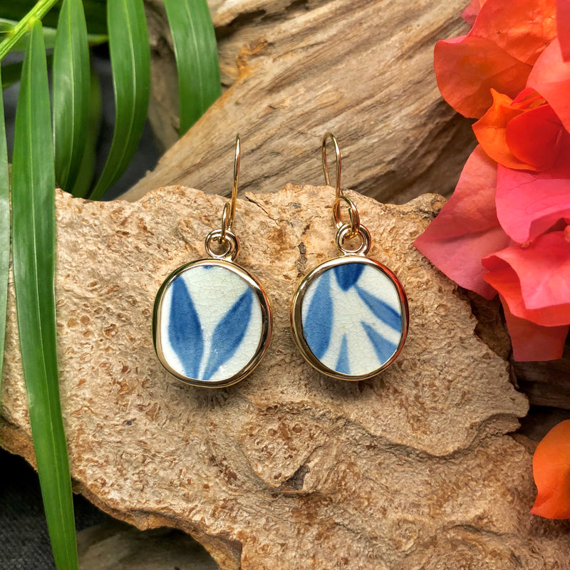 14k gold earrings with round Chaney inlay with white and blue leaf motif.
