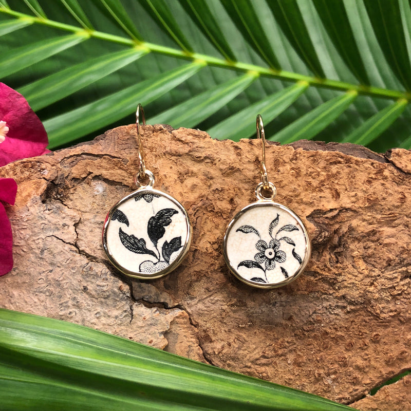 !4k gold drop earrings with round Chaney inlay with brown flower and leaf motif on white background.